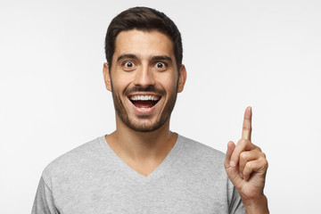 I have an idea! Handsome man keeping finger pointed upwards, making gesture with index finger