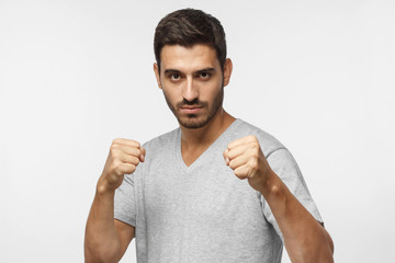 Confident sporty boxing man holding fists in front of him, going to fight and defend himself, ready...