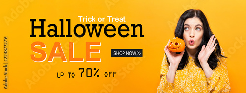 Halloween sale with young woman holding a pumpkin