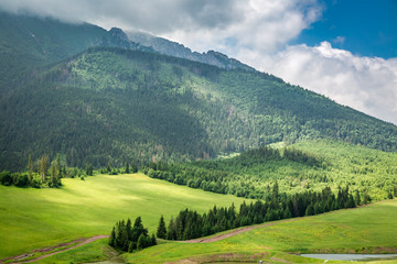Obraz premium Cloudy Tatra Mountains and green valley, Slovakia