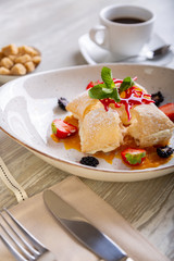 Close up view of beautiful elegant sweet dessert, Napoleon, served on the plate. Beautiful decoration, restaurant dish, ready to eat. Tea time, cozy atmosphere.