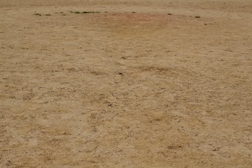 The texture of the infield dirt on a baseball field.