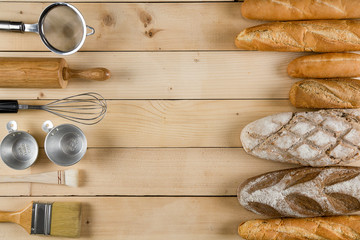 variety kinds of bread on wooden table with variety of baking tools