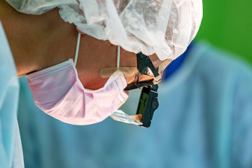 female surgeon doctor wearing protective mask and hat during the operation. Healthcare, medical education, emergency medical service, surgery concept.