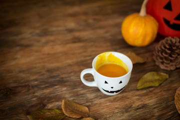 Pumpkin soup in a cup with Halloween anthropomorphic smiley face. Halloween lifestyle conceptual...