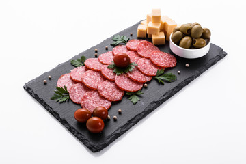 delicious sliced salami on a stone plate white background