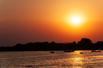 Naklejka premium Sunset over the bay. Boats on the water.