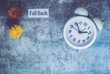 Fall Daylight Saving Time concept with white clock and flowers, flat lay