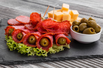 delicious sliced salami on a stone plate wooden background