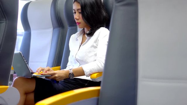 Young business woman working with a laptop computer in the Soekarno-Hatta Airport Railink Services. Shot in 4k resolution