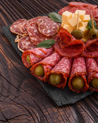 Cold smoked meat plate on a rustic wooden background