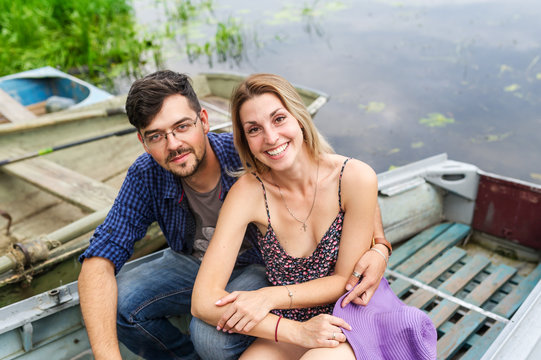 Family portrait of couple in the boat on the beautiful lake.