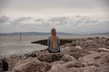 Blonde Girl from the Back at Irish Sea on Rocks