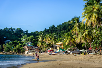Few tourists enjoying a amazing tropical beach in the late sunset. Trinidad and Tobago, Caribe