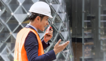 Construction engineering worker/manager talking on radio.Construction engineer use radio communication. Foreman control work through walkie-talkie