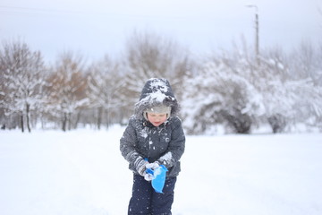 Fototapeta na wymiar child warm jacket actively plays snow rejoices
