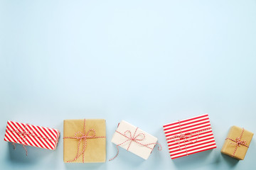 Obraz premium A lot of christmas presents wrappend in red, white and craft paper tied with baker's twine string. Multiple new years gifts in different wrapping. Top view, close up, copy space, background, flat lay.