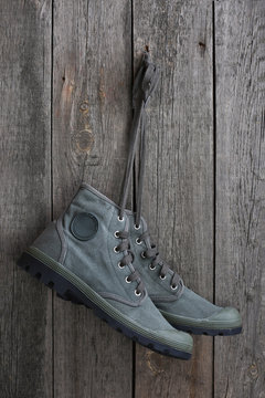 Green sneakers hanging on a wooden wall