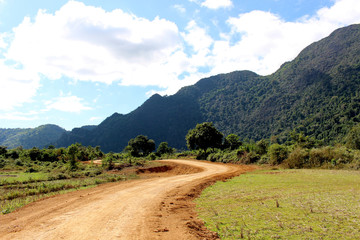 Fototapeta na wymiar Country roads at Vang Vieng, Laos : The view of two side filled with beautiful mountains