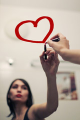 Inscription lipstick on mirror and reflection of a girl