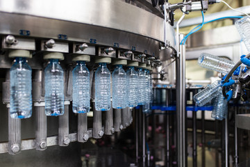 Bottling plant - Water bottling line for processing and bottling carbonated water into bottles. Selective focus.