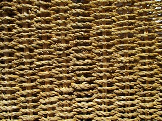 Macrophotographie lumineuse d'une vannerie en jonc de mer, réalisant un fond rustique naturel.
