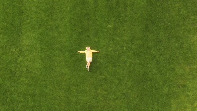 Aerial view of a woman lying in a grass