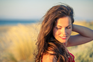 Outdoor portrait of attractive young woman enjoying evening sun