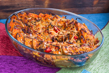 Vegetarian dish with baked orange pumkin, vegetables, herbs, cheese