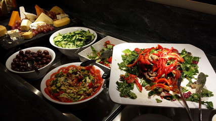 Greek salads, olives, sliced cucumbers and various cheeses.