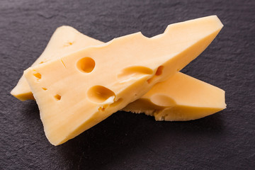 Piece and slices of cheese on a white background