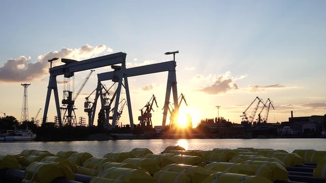 Innovative manufacture facility shipbuilding factory crane production silhouette in beautiful evening sunset skyline