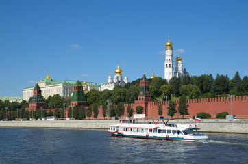 Summer view of the Moscow Kremlin and floating on the Moscow-river pleasure ship. Moscow, Russia