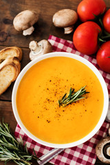 Homemade Butternut Squash Soup with Rosemary Herbs and Toppings. Hot  Pumpkin cream-soup in a white bowl.