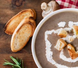Mushroom cream soup with herbs and spices. Homemade, country styled chanterelle Cream-soup on wooden table.