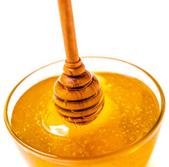 Glass jar with  honey and dipper isolated on white background. Organic bee products..
