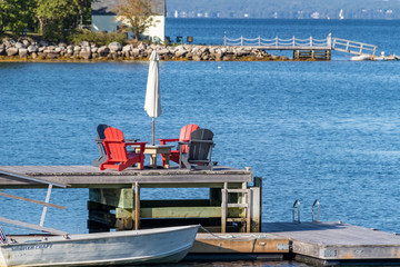 Fototapeta na wymiar Chairs on wooden dock with blurred background.