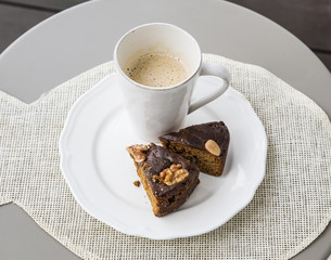 Two slices of Bolo de mel is a traditional cake from the Madeira Islands on white plate, white cup...