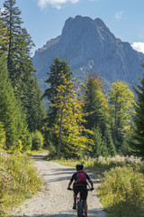 nice and active senior woman, riding her e-mountainbike in the Tannheim valley, Tirol, Austria with...