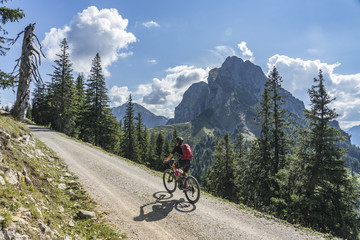 nice and active senior woman, riding her e-mountainbike in the Tannheim valley, Tirol, Austria with...