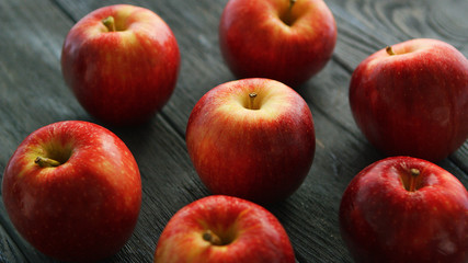 Closeup heap of red fresh apples on dark rough wooden background 