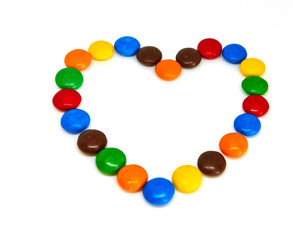 colorful chocolate buttons in the shape of heart on a white background