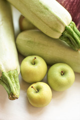 Whole ripe vegetable marrow and apples lie on the windowsill.