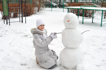 The girl is making a snowman