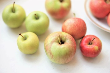 several whole apples on a white table