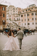 Obraz premium Young wedding couple near Spanish steps (Scalinata di Trinità dei Monti) in Rome, Italy