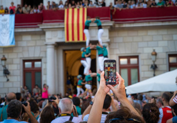 Hand held smartphone taking a picture of Castells Performance