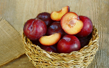 Plum Benefits Your Digestion & Cardiovascular Health.
Many Plums(German name is Pflaumen dunkel ) in basket on wooden background.
