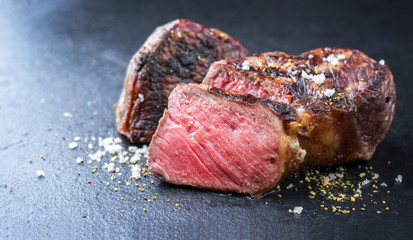 Barbecue wagyu roast beef sliced as top view on a metal board with copy space left