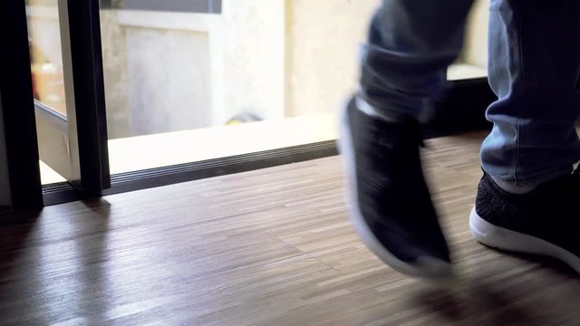 Close up of one person's feet walking inside the house without taking shoes off - Western Tradition of not removing shoes in home